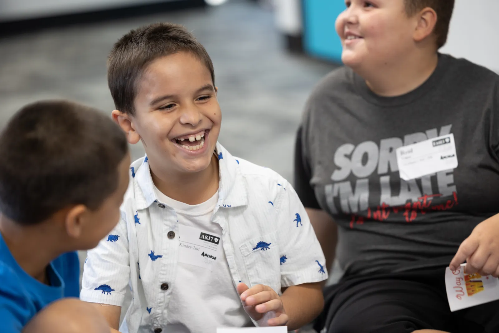 A boy laughing with friends in an Anchor Kidz small group