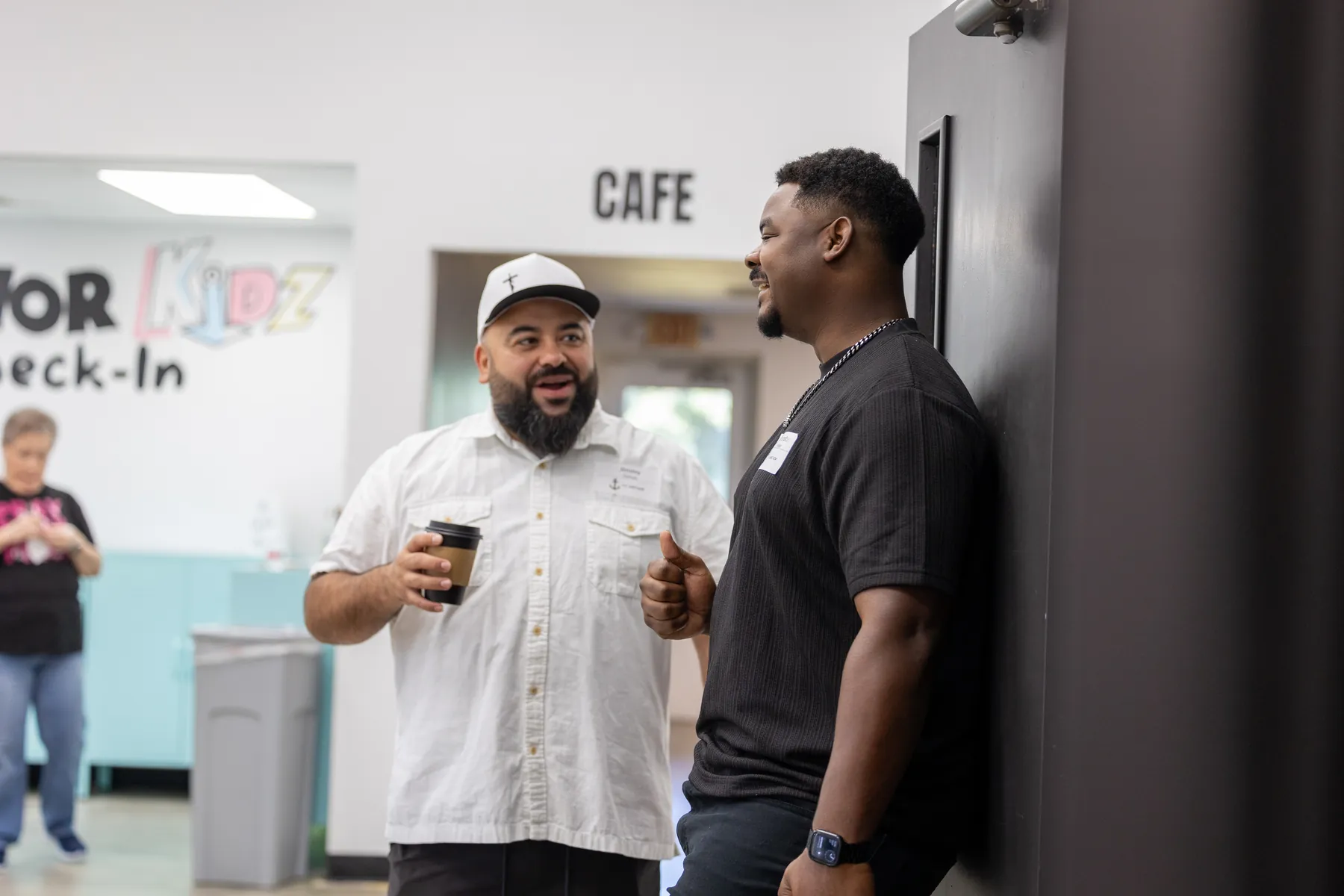 Two men laughing over coffee in the lobby