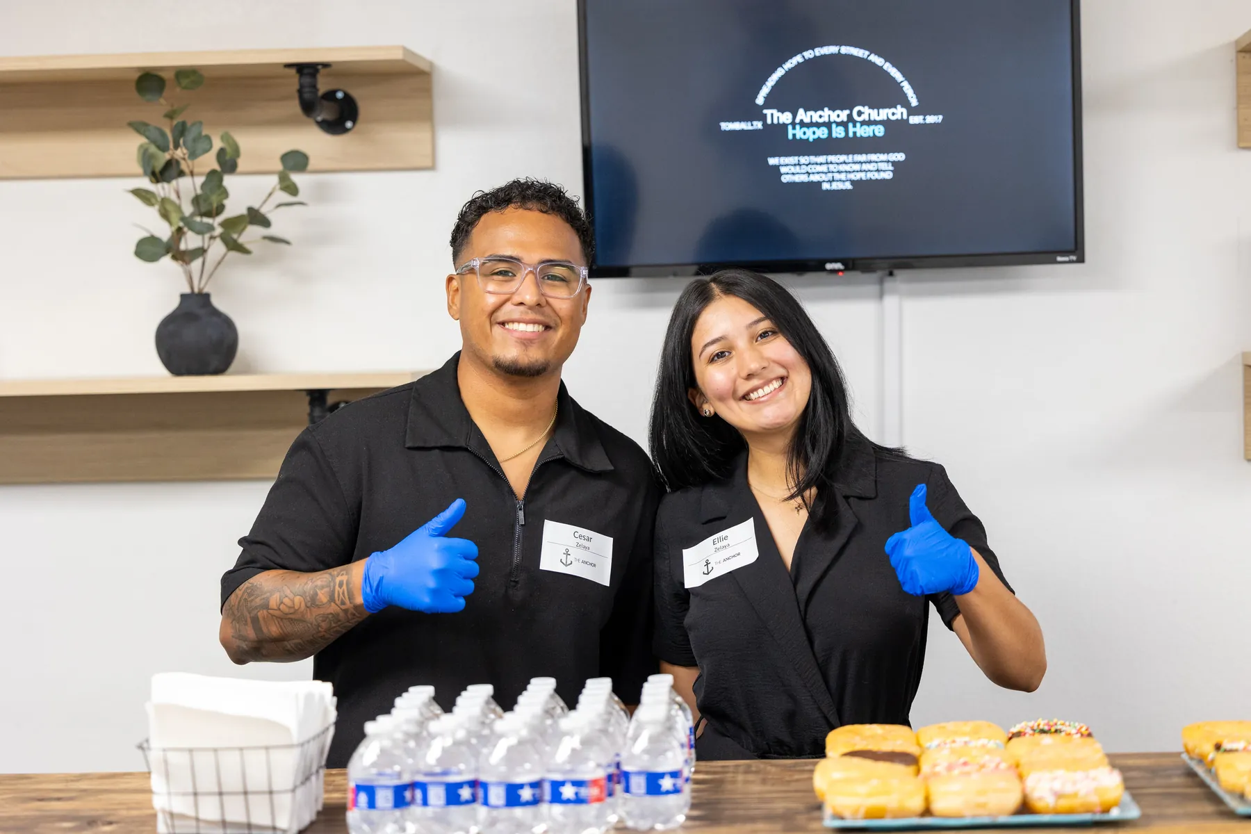 Two volunteers smiling at the welcome table