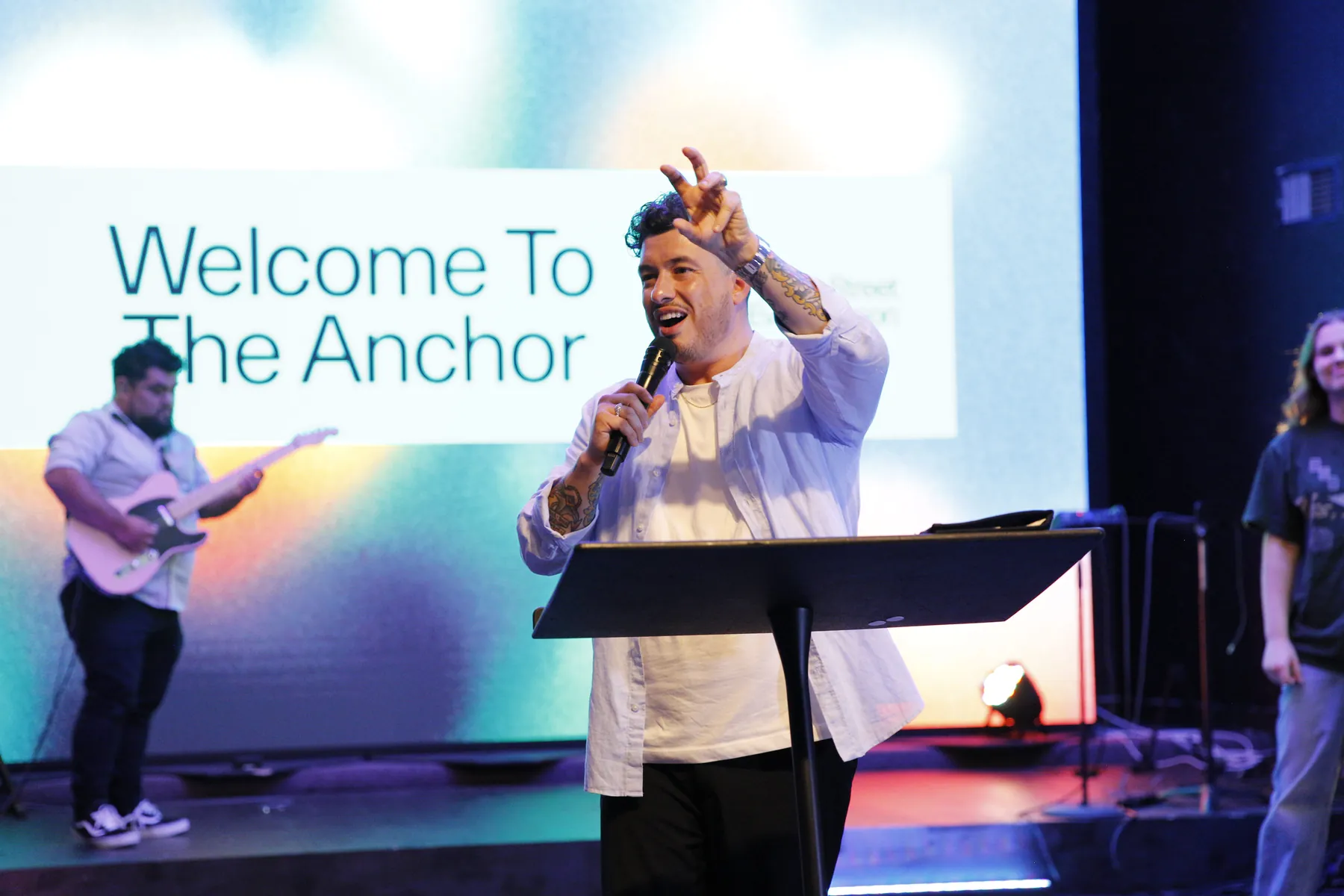 Pastor Rafael on stage in front of a Welcome to The Anchor slide