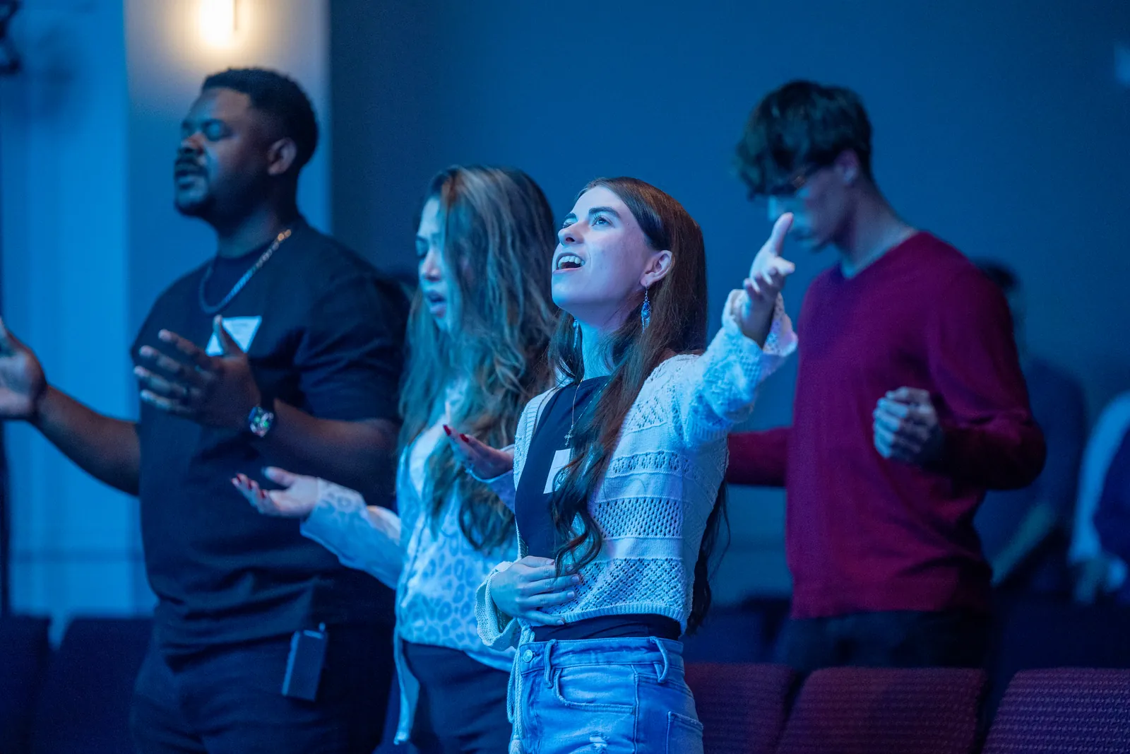 A young woman worshipping during a Sunday gathering